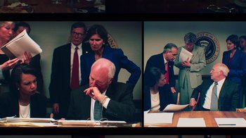 Movie still from “9/11: Inside the President's War Room” (2021), directed by Adam Wishart – A group of men and women standing around a table; Medium shot, High angle