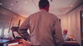 Movie still from “9/11: Inside the President's War Room” (2021), directed by Adam Wishart – A man standing in front of another man in a room; Medium shot, Over the shoulder angle