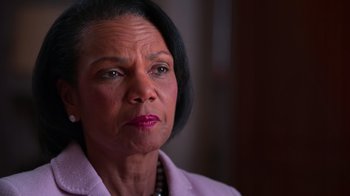 Movie still from “9/11: Inside the President's War Room” (2021), directed by Adam Wishart – An image of an older woman looking at the camera; Close Up shot, Over the shoulder angle