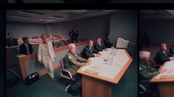Movie still from “9/11: Inside the President's War Room” (2021), directed by Adam Wishart – A group of men sitting at a table in front of a computer; Wide shot, High angle
