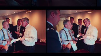 Movie still from “9/11: Inside the President's War Room” (2021), directed by Adam Wishart – A group of men standing next to each other in a room; Medium shot, High angle