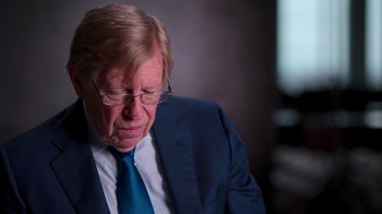 Movie still from “9/11: Inside the President's War Room” (2021), directed by Adam Wishart – An older man wearing a suit and tie; Close Up shot, Over the shoulder angle
