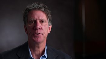 Movie still from “9/11: Inside the President's War Room” (2021), directed by Adam Wishart – A person wearing a suit; Close Up shot, High angle