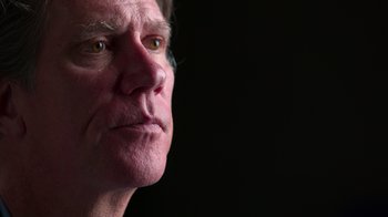 Movie still from “9/11: Inside the President's War Room” (2021), directed by Adam Wishart – An older man looking into the distance with a serious look; Close Up shot, Low angle