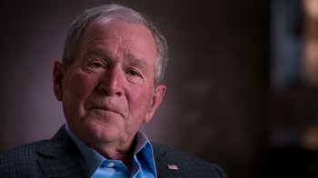 Movie still from “9/11: Inside the President's War Room” (2021), directed by Adam Wishart – An older man wearing a blue shirt and a black jacket; Close Up shot, Over the shoulder angle