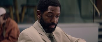Movie still from “A Banquet” (2021), directed by Ruth Paxton – A person wearing a suit and tie; Close Up shot, High angle
