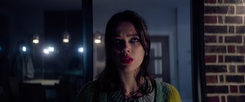 Movie still from “A Banquet” (2021), directed by Ruth Paxton – A woman is looking at the camera while standing in front of a window; Close Up shot, Low angle