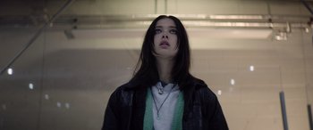 Movie still from “A Banquet” (2021), directed by Ruth Paxton – A woman with long black hair wearing a leather jacket; Close Up shot, Low angle