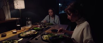 Movie still from “A Banquet” (2021), directed by Ruth Paxton – Two women sitting at a table with plates of food on it; Medium shot, Over the shoulder angle