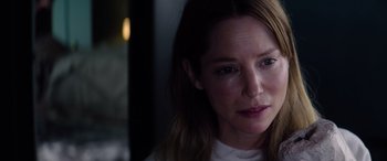 Movie still from “A Banquet” (2021), directed by Ruth Paxton – A woman's face in a dark room; Close Up shot, Over the shoulder angle