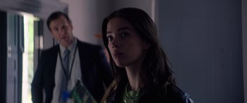 Movie still from “A Banquet” (2021), directed by Ruth Paxton – A woman with long brown hair is looking at the camera; Close Up shot, Over the shoulder angle