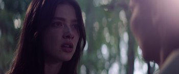 Movie still from “A Banquet” (2021), directed by Ruth Paxton – A woman's face in front of trees; Close Up shot, Low angle