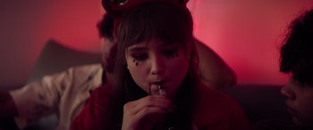 Movie still from “A Banquet” (2021), directed by Ruth Paxton – A girl with cat ears is smoking a cigarette; Close Up shot, High angle