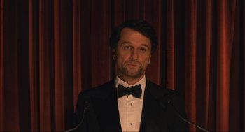 Movie still from “A Beautiful Day in the Neighborhood” (2019), directed by Marielle Heller – A man in a tuxedo standing in front of a microphone; Close Up shot, Low angle
