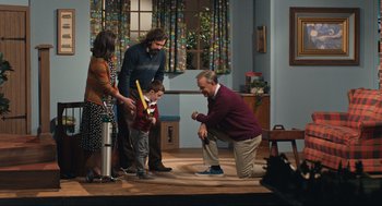 Movie still from “A Beautiful Day in the Neighborhood” (2019), directed by Marielle Heller – A man kneeling down on the floor with a child and an adult; Wide shot, High angle