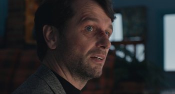 Movie still from “A Beautiful Day in the Neighborhood” (2019), directed by Marielle Heller – A man's face in a dark room; Close Up shot, Over the shoulder angle