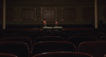 Movie still from “A Beautiful Day in the Neighborhood” (2019), directed by Marielle Heller – Two men are sitting in a theater with laptops; Wide shot, High angle