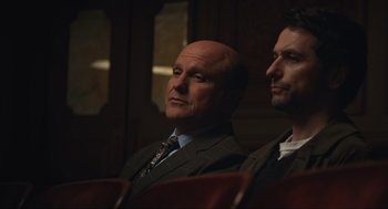 Movie still from “A Beautiful Day in the Neighborhood” (2019), directed by Marielle Heller – Two men in suits are sitting in a theater; Medium shot, Low angle