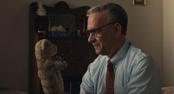 Movie still from “A Beautiful Day in the Neighborhood” (2019), directed by Marielle Heller – An older man sitting in front of a teddy bear; Close Up shot, Over the shoulder angle