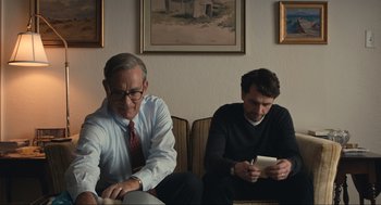 Movie still from “A Beautiful Day in the Neighborhood” (2019), directed by Marielle Heller – Two men sitting in a living room next to each other; Medium shot, Over the shoulder angle