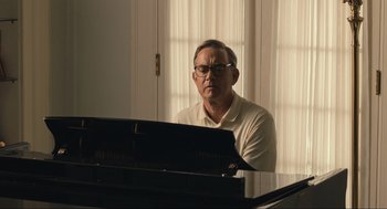 Movie still from “A Beautiful Day in the Neighborhood” (2019), directed by Marielle Heller – An older man sitting in front of a black piano; Medium shot, Over the shoulder angle
