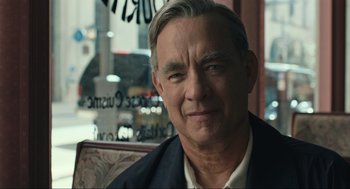 Movie still from “A Beautiful Day in the Neighborhood” (2019), directed by Marielle Heller – A person sitting in a chair wearing a suit; Close Up shot, Over the shoulder angle