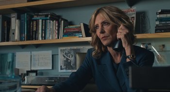 Movie still from “A Beautiful Day in the Neighborhood” (2019), directed by Marielle Heller – A woman sitting at a desk talking on a phone; Medium shot, Over the shoulder angle