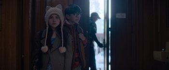 Movie still from “A Christmas Mystery” (2022), directed by Alex Ranarivelo – Two children standing next to each other in front of a door; Medium shot, Over the shoulder angle