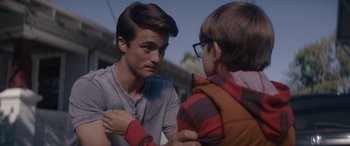 Two young men talking to each other on a street