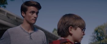 Movie still from “A Christmas Mystery” (2022), directed by Alex Ranarivelo – Two young men standing next to each other in front of a building; Close Up shot, Over the shoulder angle