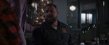 Movie still from “A Christmas Mystery” (2022), directed by Alex Ranarivelo – A man with a beard is sitting in front of a christmas tree; Close Up shot, Over the shoulder angle