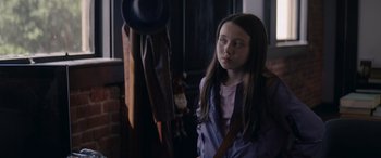 Movie still from “A Christmas Mystery” (2022), directed by Alex Ranarivelo – A young girl standing in front of a hat rack; Close Up shot, Over the shoulder angle