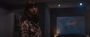 Movie still from “A Christmas Mystery” (2022), directed by Alex Ranarivelo – A woman standing in front of a projection screen; Medium shot, Over the shoulder angle
