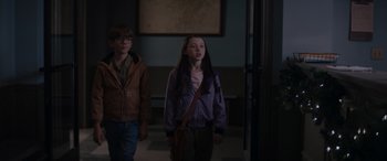 Movie still from “A Christmas Mystery” (2022), directed by Alex Ranarivelo – A young girl and a young boy are walking in a hallway; Medium shot, Over the shoulder angle