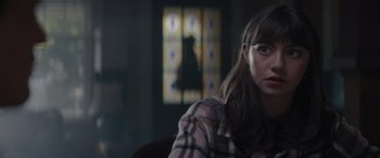 Movie still from “A Christmas Mystery” (2022), directed by Alex Ranarivelo – A woman sitting in front of a stained glass window; Close Up shot, Over the shoulder angle