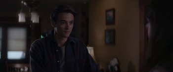 Movie still from “A Christmas Mystery” (2022), directed by Alex Ranarivelo – A young man in a plaid shirt is looking at the camera; Close Up shot, Over the shoulder angle