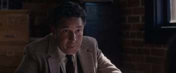 Movie still from “A Christmas Mystery” (2022), directed by Alex Ranarivelo – A person wearing a suit and tie; Close Up shot, Over the shoulder angle