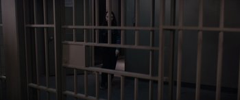 Movie still from “A Christmas Mystery” (2022), directed by Alex Ranarivelo – A woman standing in a jail cell behind bars; Wide shot, High angle