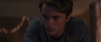 Movie still from “A Christmas Mystery” (2022), directed by Alex Ranarivelo – A young man is staring at the camera; Close Up shot, Over the shoulder angle