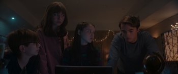 Movie still from “A Christmas Mystery” (2022), directed by Alex Ranarivelo – A group of people standing in front of a computer; Medium shot, Over the shoulder angle