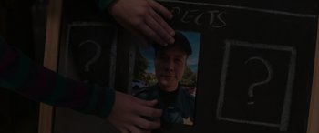 Movie still from “A Christmas Mystery” (2022), directed by Alex Ranarivelo – A person holding a picture of a man in a hat; Extreme Close Up shot, Overhead angle