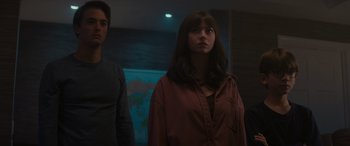 Movie still from “A Christmas Mystery” (2022), directed by Alex Ranarivelo – A woman standing next to a man in front of a map; Medium shot, Low angle