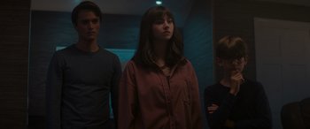 Movie still from “A Christmas Mystery” (2022), directed by Alex Ranarivelo – A group of young people standing next to each other in a room; Medium shot, Low angle