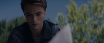 Movie still from “A Christmas Mystery” (2022), directed by Alex Ranarivelo – A young man looking down at a piece of paper; Close Up shot, Over the shoulder angle