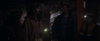 Movie still from “A Christmas Mystery” (2022), directed by Alex Ranarivelo – A man and a woman standing next to each other in the dark; Medium shot, Low angle