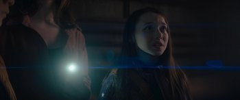 Movie still from “A Christmas Mystery” (2022), directed by Alex Ranarivelo – A woman looking up at the sky with a flashlight in her hand; Close Up shot, Over the shoulder angle