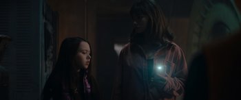 Movie still from “A Christmas Mystery” (2022), directed by Alex Ranarivelo – Two people standing next to each other with a light in their hand; Medium shot, Low angle