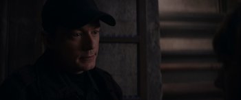 Movie still from “A Christmas Mystery” (2022), directed by Alex Ranarivelo – A man wearing a black hat looking at the camera; Close Up shot, Over the shoulder angle