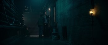 Movie still from “A Christmas Mystery” (2022), directed by Alex Ranarivelo – Two men are standing in a dark room; Wide shot, High angle