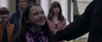 Movie still from “A Christmas Mystery” (2022), directed by Alex Ranarivelo – A young girl smiles as a woman stands behind her; Close Up shot, Over the shoulder angle